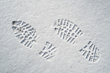 Clearly defined footprints / imprints in fresh snow of rubber lug soles with deep indentations from mountaineering boots / hiking boots in winter