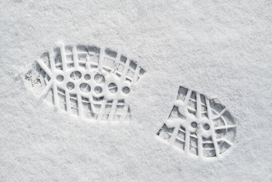 Clearly defined footprint / imprint in fresh snow of rubber lug sole with deep indentations from mountaineering boot / hiking boot in winter