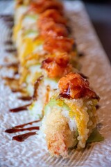 Ebi roll (gambero in tempura, alga di soia verde, maionese, tartare di salmone all’esterno, fiore di zucca in tempura, ikura, salsa teriyaki)