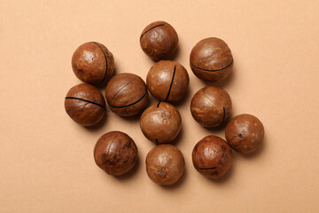 Group of tasty macadamia nuts on beige background