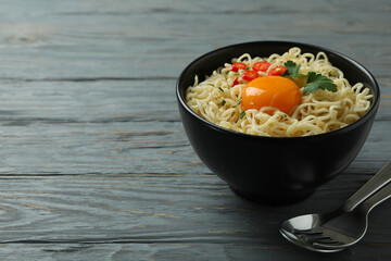 Concept of tasty eating with bowl of noodles on wooden background