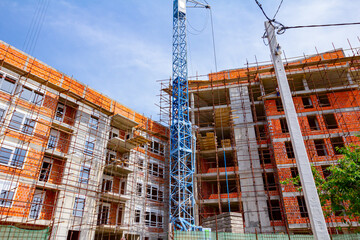 View below on empty scaffold and crane truss at construction site