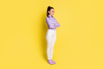 Fototapeta na wymiar Full length body size photo woman smiling with folded hands looking empty space isolated on vivid yellow color background