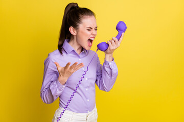 Photo portrait pretty girl irritated angry shouting in telephone arguing with operator in purple shirt isolated on bright yellow color background