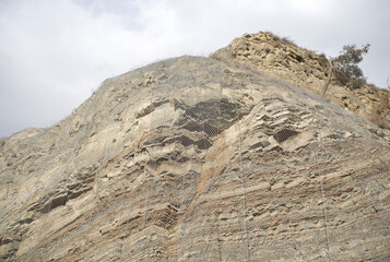 Metal protective mesh on a cliff. Protective grid.