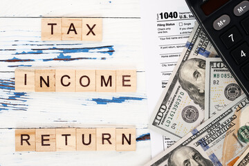 Personal income tax form 1040, dollar bills and calculator. Tax payment and filing concept. 