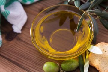 glass vessel with extra virgin olive oil and olives with branch