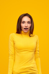 Astonished young woman in yellow wear