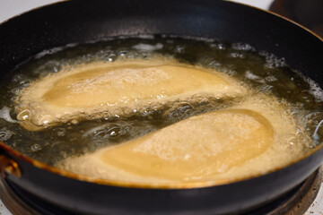 Process with  fried in sunflower oilof homemade qutab or chebureki, calzone with minced meat and onion. Process of making food at the kitchen. Azerbaijani, Tatar, Caucasian, Greek cuisine. 