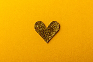 Shiny golden Heart shape sticker on yellow background