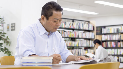 図書館で勉強する中高年男性