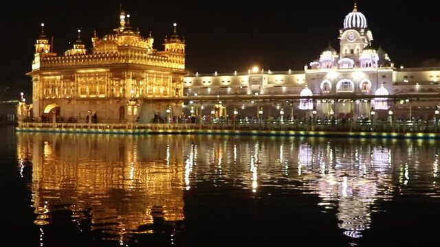 Amritsar, Punjab, India - January 06, 2019 : golden temple with reflection in the water at night