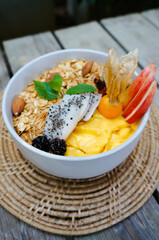 Healthy food smoothie bowl Fresh fruit smoothie is good for the body. with mango, banana, nuts, seeds, papaya, almonds, sunflower and homemade granola and apple for healthy on the table.