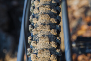 A spiked mountain bike wheel in the sand. Selective Focus