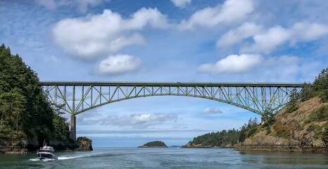View looking West from boat transiting Deception Pass with bridge above and another boat going by.