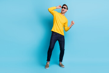 Fototapeta na wymiar Full length photo of carefree person hand touch sunglass open mouth dancing isolated on blue color background
