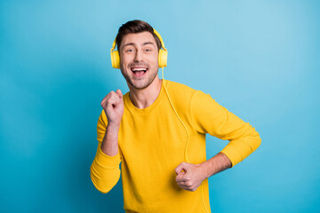 Portrait of attractive cheerful guy listening single melody having fun isolated over bright blue color background