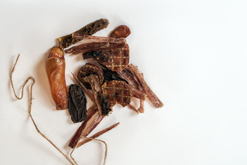 Some cut pieces of dehydrated beef treats for pets, dry dog food, home-made and natural. White background, close up, copy space.