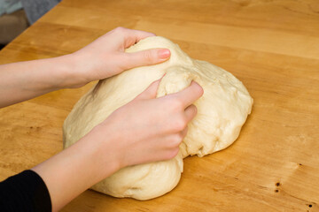 Woman hands knead dough on the kitchen table. Homemade dough. homemade baking