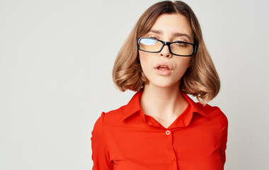 Confident business woman in a red shirt and glasses emotions beige background
