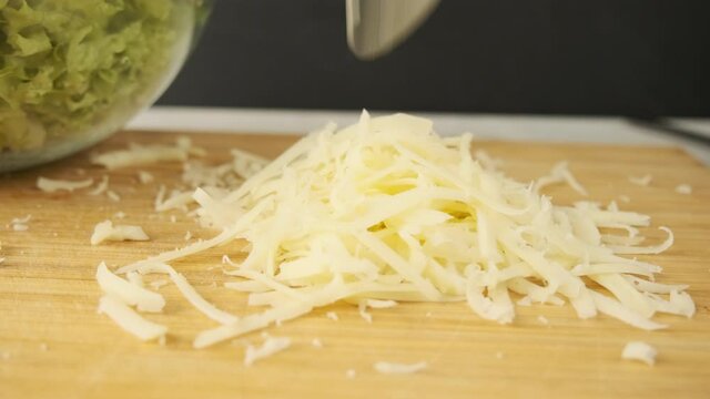 Grate the cheese on a grater. Chef grating hard cheese in an outdoor kitchen. Slow -motion