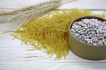 Dry wheat pasta on a wooden background.