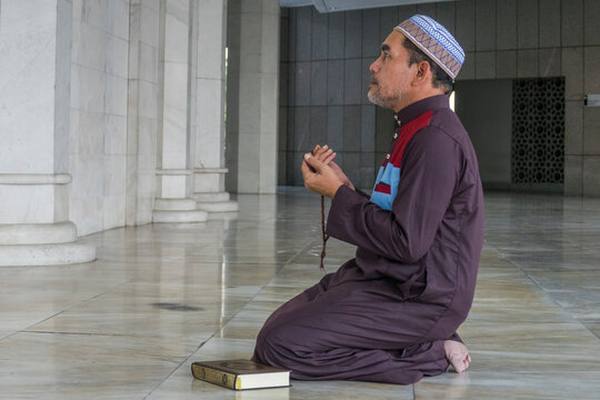 Side View Of Mature Man Praying While Kneeling At Mosque