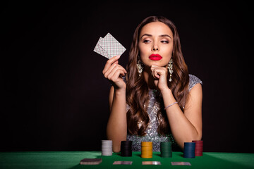 Photo of lady sit casino table hold two cards raise bet wear glossy dress isolated black color...