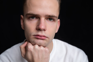 Fototapeta premium portrait of a serious handsome pensive guy on a black background