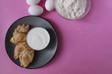 boiled dumplings lie on a gray plate with sour cream on a pink background cooking the traditional dish of slavic copyspace place for text