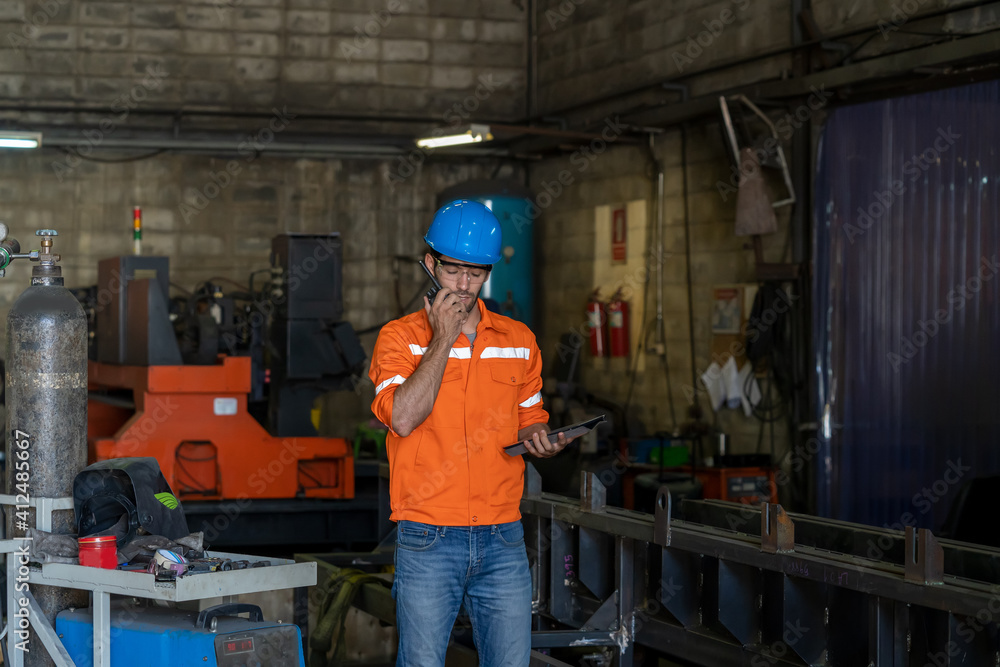 Fototapete technician engineer use radio to communicate assign in the factory.
