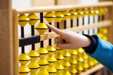 Smart kid counting on soroban abacus. Education, school arithmetic, calculating thinking