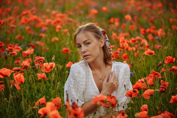 a girl in a white dress posing in a field with poppies