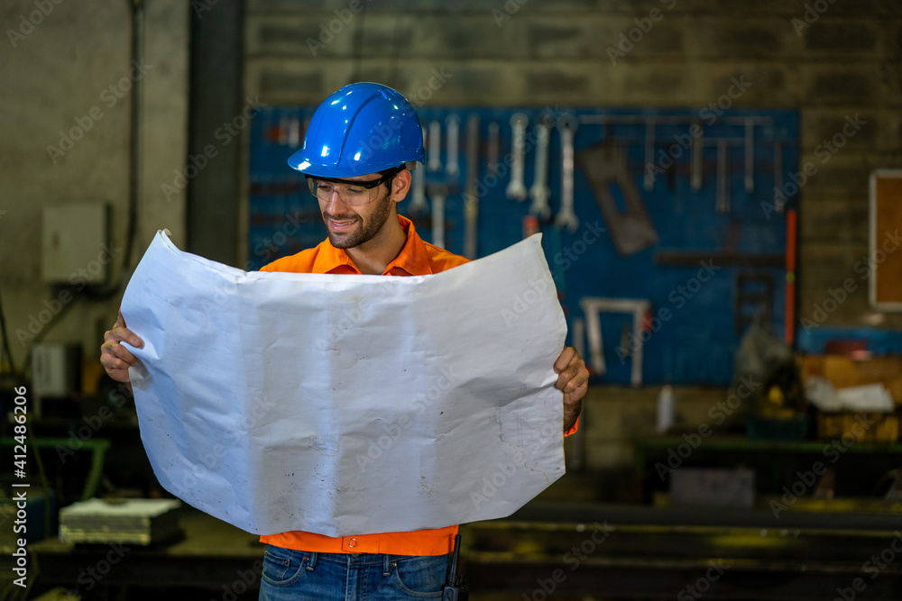 Leinwandbilder engineer in factory watching blueprint for the working process.