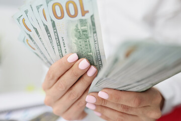 Female hands are counting American hundred dollar bills. Fast money on the Internet without...
