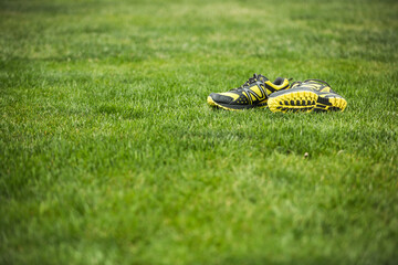 taking off shoesand enjoying walking barefoot. Running shoes on green grass