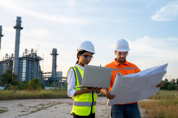 Engineer working with blueprint at the oil refinery industry background.