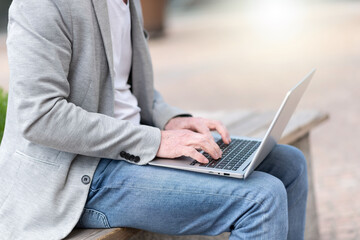 Fototapeta premium Businessman using laptop outdoors