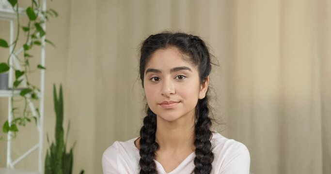 Portrait of young indian caucasian teen girl with serious expression looking at camera waving her finger negatively answers condemnation on question prohibits restrains making gesture of disapproval