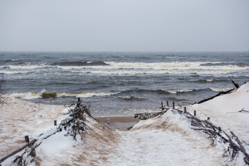 Baltic Sea beach is snowy in winter and there are big waves