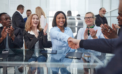 smiling businesswoman shaking hands with her business partner.