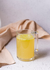 selective focus. Homemade Beef Bone Broth in a transparent mug. on a light gray background. with the addition of spices-salt and pepper. Bones contain collagen