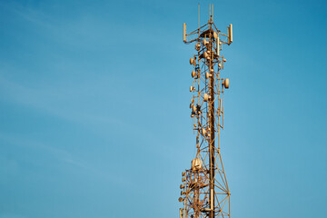 Communication tower with antennas against blue sky