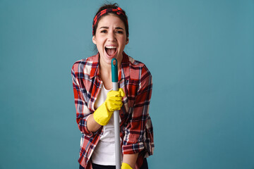 Joyful caucasian woman in gloves singing while making fun with mop