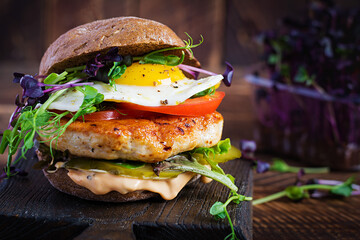 Hamburger. Sandwich with chicken burger, tomatoes,  pickled cucumber and fried egg. Fresh tasty...