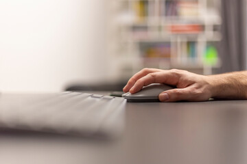 Close up view of a hand with a wireless mouse. Work from home, online study.