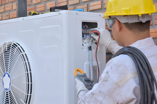 Engineer installing an air conditioning unit, Thailand