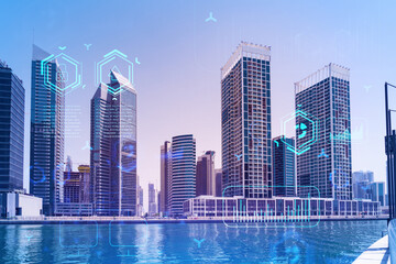 Skyscrapers of Dubai business downtown. International hub of trading and financial services. Technology theme icons hologram, Fintech concept. Double exposure. Dubai Canal waterfront.