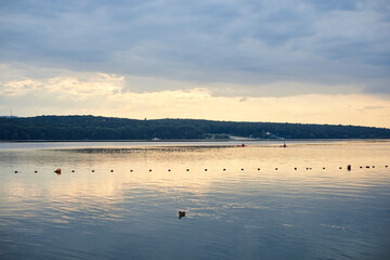 Naklejka premium Amazing lake landscape in the evening. Blue yellow cloudy sky with reflection in water at sunset. Nature protection concept. Rural scene in countryside. Ecological conservation.Eco tourism development