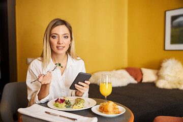 Obraz na płótnie Canvas Modern business lady having breakfast in her hotel room